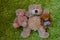 Three teddy bears laying on green furry carpet