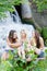 Three teenage girl friends having fun near waterfall on summer day outdoors