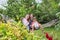 Three teenage girls and child having fun laughing on hammock in garden