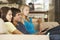 Three Teenagers Sitting On Sofa At Home Texting On Mobile Phones