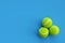 Three tennis balls on blue background with copy space. 3D rendering. Flat lay overhead view