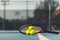 Three tennis balls on a professional racket on acrylic blue surface