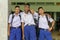 Three Thai students in their school uniform is standing by and embracing each other in front of the camera in Wanthamaria school