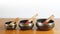 Three Tibetan bowls on a wooden table with white wall background