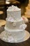 Three tier wedding cake with cream roses and decorations