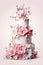 A three tiered cake with pink flowers on top.