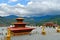 Three-tiered roof of the Dordenma Buddha temple against the backdrop of mountains and cloudy sky