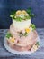 Three-tiered wedding ombre cake decorated with roses and greener