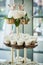 A three tiered wooden display with cupcakes