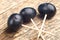 Three toothpicks on which are strung grape berries, natural wooden old background