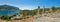 Three tourist boats moored at island with ancient ruins panorama