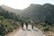 Three tourists with backpacks travel in the mountains