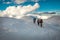 Three tourists hiking in winter mountains