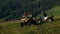 Three tourists on quad bikes in mountain.