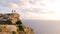 Three tourists stand on the edge of a cliff at a great height and look at the horizon, chatting. Calm sea and big clouds