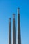 Three towering concrete smoke stacks of decommissioned power plant soaring into blue sky