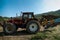 Three tractors plowing a field