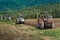 Three tractors plowing a field