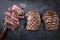 Three traditional barbecue entrecote beef steaks with salt and pepper on a rustic old board