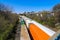 Three trains riding on the railroad tracks surrounded by lush green trees and bare winter trees and clear blue sky in Atlanta