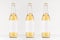 Three transparent longneck beer bottles 500ml with blank white label on white wooden board, mock up.