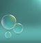 Three transparent soap bubbles with shadows on cyan