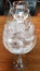 Three transparent wine glasses in a row with one glass full of ice cubes and two empty glasses. Icing texture. Still life on table