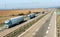 Three transportation Trucks in line on a rural countryside highway