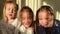 Three triplet sisters with closed eyes close-up then slowly open eyes and smile