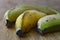 Three tropical bananas with husk macro view