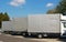 Three trucks with gray canvas standing in a row at a highway par