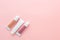 three tubes of cosmetic creams without a name on a pink background