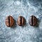 Three types of coffee beans on a marble background
