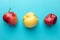 Three ugly apples are lying in row on turquoise painted wooden  background