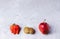 Three ugly fruits: strawberry, kiwi and apple on grey concrete background.