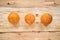 Three ugly non-standard mandarin lying in row on natural wooden background.