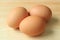 Three uncooked fresh chicken eggs isolated on the wooden table