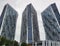 Three unfinished high-rise buildings next to each other for the entire frame. View from below