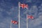 Three Union Jacks flying proudly against blue sky