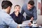 Three upset males with papers at table