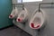 three urinals in a mens public bathroom or mens public toilet
