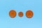 Three Various orange sewing buttons on blue background