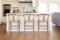 three varnished oak counter chairs in a neutral-toned kitchen