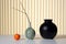 Three vases and an orange on a table, AI