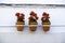 Three vibrant red geranium flowers in flowerpots hang in line from a white house wall