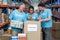 Three volunteers packing eatables in cardboard box