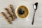 Three wafer rolls with chocolate filling, black coffee in cup, spoon on wooden table. Top view