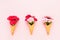 Three waffle ice cream cones with pink carnation flowers on pink background. Top view, copy space