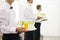 Three waiters in bow ties holding trays.