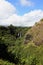 Three waterfalls, Opaeka\\\'a Falls, cascading over a volcanic rock cliff, surrounded by rainforest in Wailua